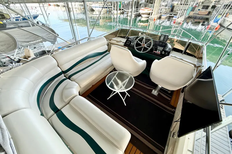 Slide: The Image of 1982 Sea Ray 355T Trawler interior with helm, seating, and marina view. - 23