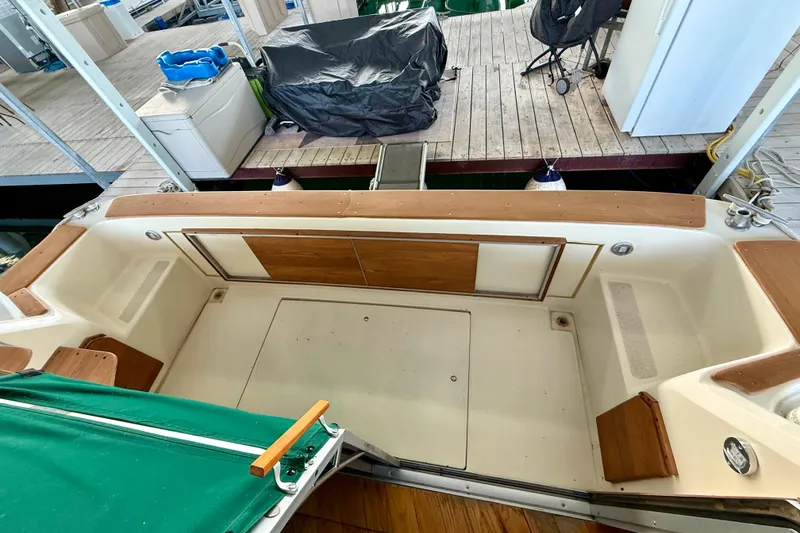 Slide: The Image of 1982 Sea Ray 355T Trawler cockpit with wooden accents and green cover at dock. - 25