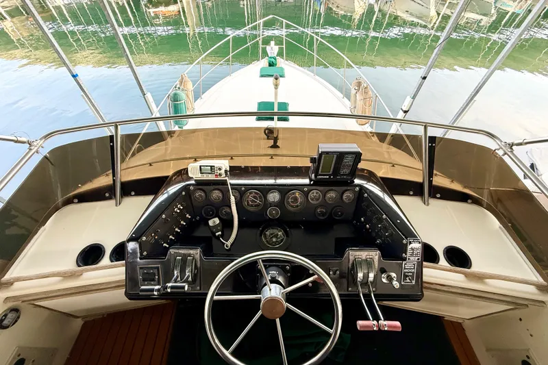 Slide: The Image of Cockpit view of 1982 Sea Ray 355T Trawler with steering wheel and control panel. - 26