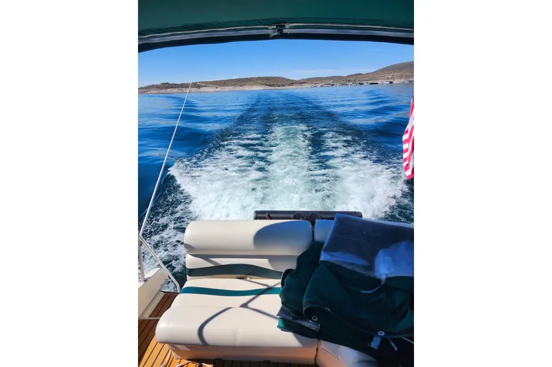Slide: The Image of Rear view from 1982 Sea Ray 355T Trawler cruising on a clear blue lake. - 28
