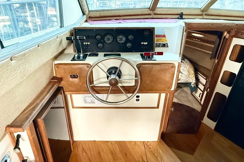 Slide: The Image of 1982 Sea Ray 355T Trawler helm with vintage steering wheel and control panel. - 4