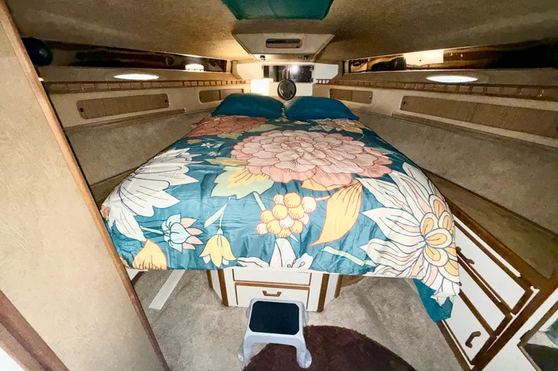 Slide: The Image of Interior cabin of 1982 Sea Ray 355T Trawler with floral bedding and cozy decor. - 8