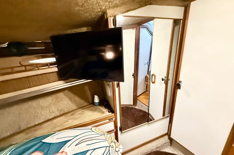 Slide: The Image of 1982 Sea Ray 355T Trawler cabin interior with TV and mirrored closet. - 9