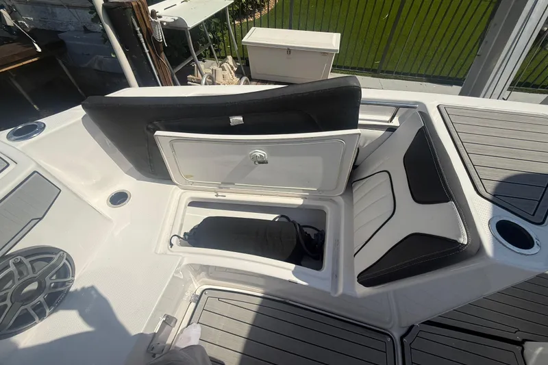 Slide: The Image of 2024 Yamaha Boats 255 FSH Sport H with open storage compartment and seating. - 11