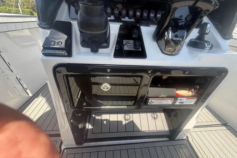 Slide: The Image of 2024 Yamaha Boats 255 FSH Sport H control panel with switches and storage compartments. - 23