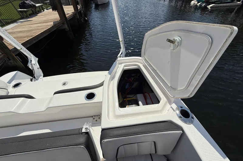 Slide: The Image of 2024 Yamaha Boats 255 FSH Sport H storage compartment open by the water. - 26