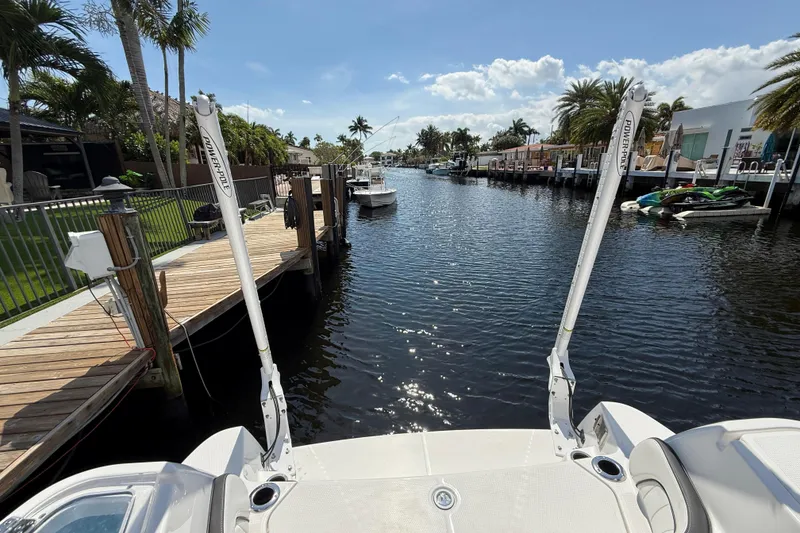 Slide: The Image of 2024 Yamaha Boats 255 FSH Sport H docked in a sunny canal setting. - 27