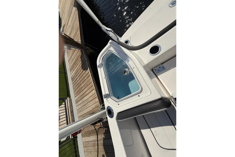 Slide: The Image of 2024 Yamaha Boats 255 FSH Sport H, docked, showcasing sleek design and spacious deck. - 28