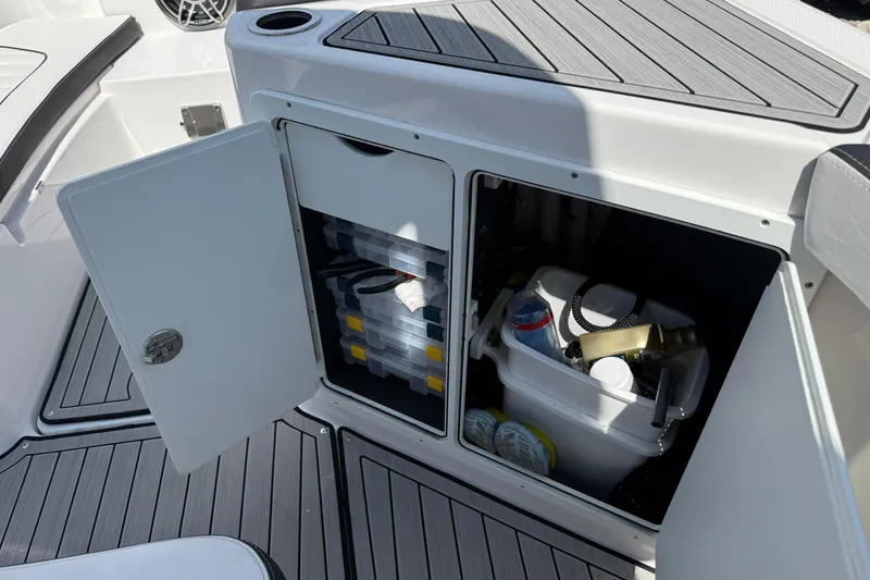 Slide: The Image of 2024 Yamaha Boats 255 FSH Sport H storage compartments with fishing gear and supplies. - 31