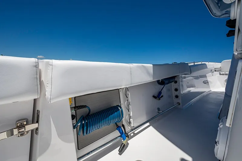Slide: The Image of 2023 Sportsman Open 352 Center Console boat interior with blue hose and white seating. - 19