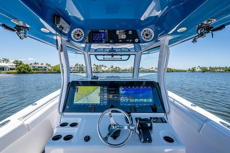 Slide: The Image of 2023 Sportsman Open 352 Center Console boat dashboard with navigation screens on a sunny day. - 5
