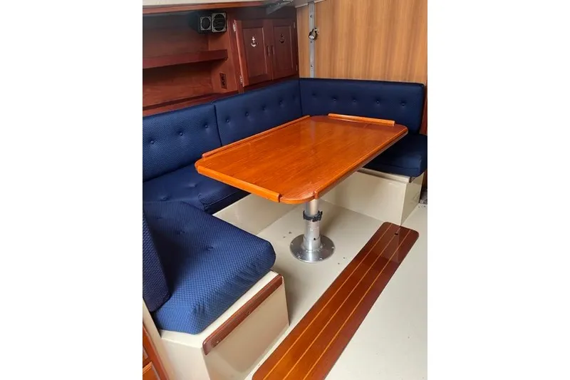 Slide: The Image of Interior of 1982 Catalina 38 sailboat with wooden table and blue cushioned seating. - 10