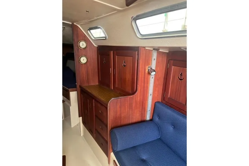 Slide: The Image of Interior of 1982 Catalina 38 sailboat with wooden cabinetry and blue seating. - 12