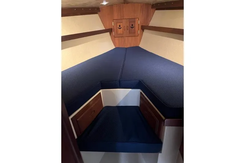 Slide: The Image of Interior cabin of a 1982 Catalina 38 sailboat with blue cushions and wooden accents. - 14