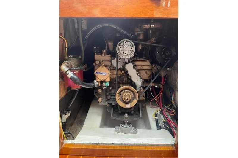 Slide: The Image of Engine compartment of a 1982 Catalina 38 sailboat, showcasing mechanical components and wiring. - 17