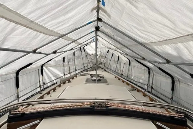 Slide: The Image of 1982 Catalina 38 sailboat under protective cover, showcasing deck and rigging. - 6