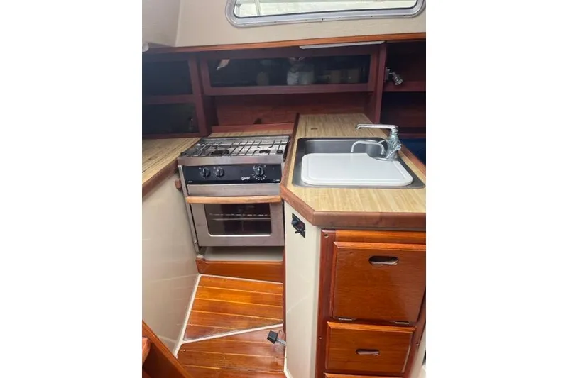 Slide: The Image of 1982 Catalina 38 yacht kitchen with stove, sink, and wooden cabinetry. - 8
