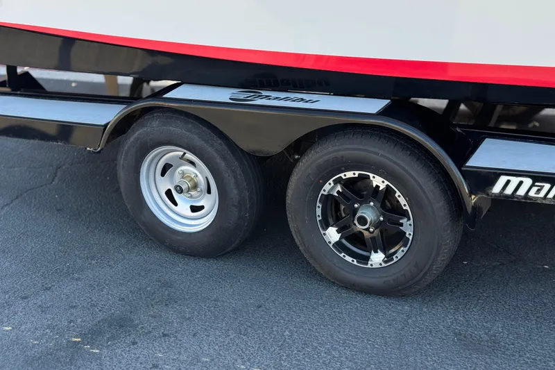Slide: The Image of Trailer wheels of a 2017 Tigé RZ2 boat on pavement. - 45