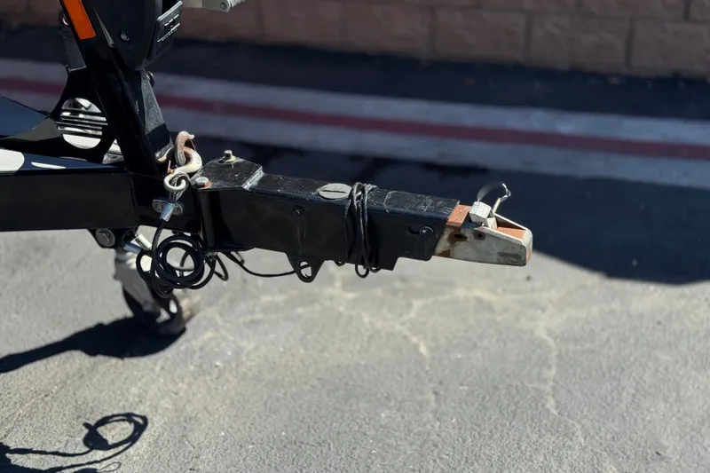 Slide: The Image of Trailer hitch of a 2017 Tigé RZ2 boat on pavement background. - 46