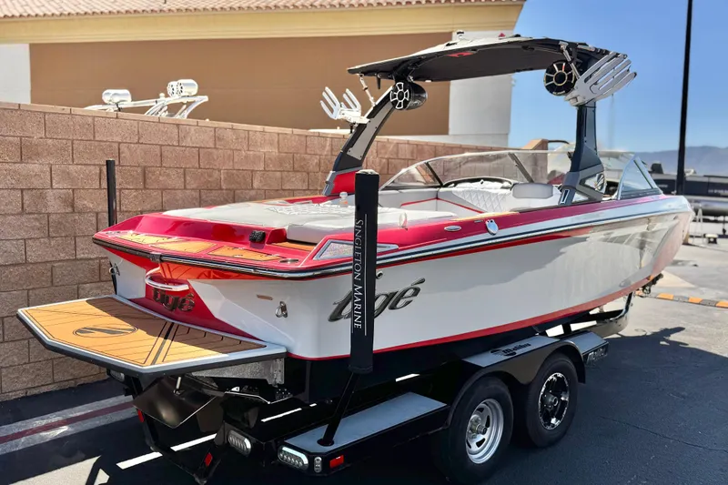 Slide: The Image of 2017 Tigé RZ2 boat on trailer, red and white design, parked outdoors. - 5