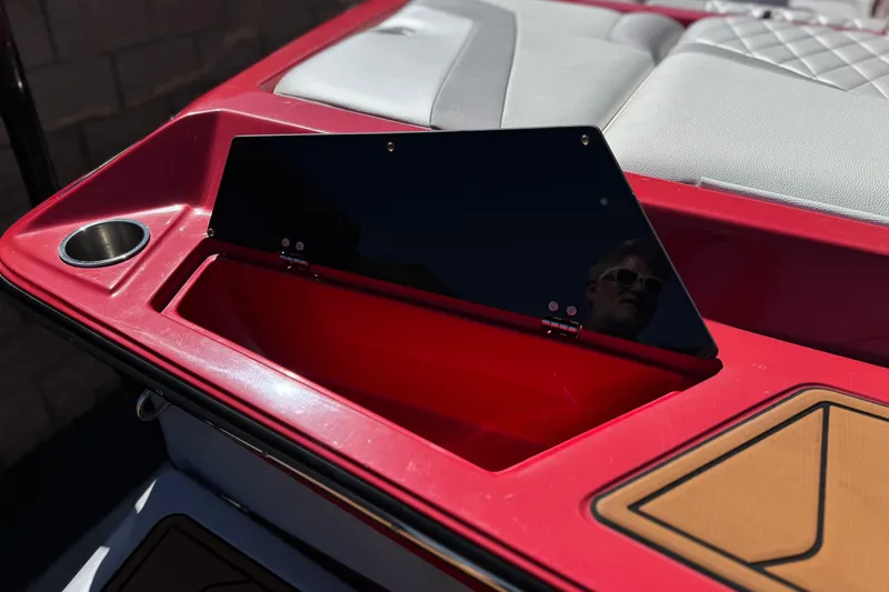 Slide: The Image of 2017 Tigé RZ2 boat interior with red storage compartment and cup holder. - 7