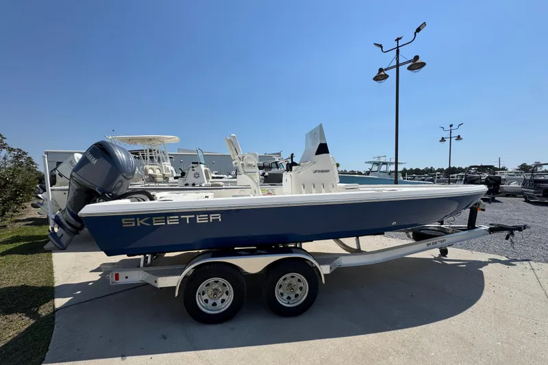 The Image of 2025 Skeeter SX221 boat on trailer under clear blue sky. - 1
