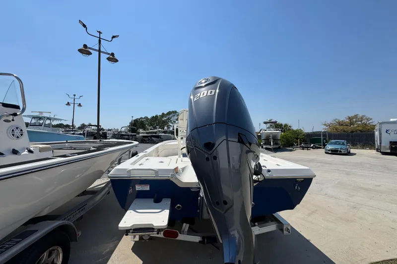 Slide: The Image of 2025 Skeeter SX221 boat with powerful outboard motor in a sunny marina. - 10