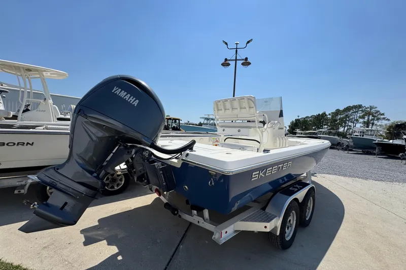 Slide: The Image of 2025 Skeeter SX221 boat with Yamaha engine on trailer, parked outdoors. - 12