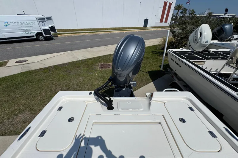 Slide: The Image of 2025 Skeeter SX221 boat with outboard motor, parked near a road and other boats. - 19