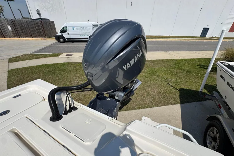 Slide: The Image of 2025 Skeeter SX221 boat with Yamaha outboard motor, parked near a white van. - 20
