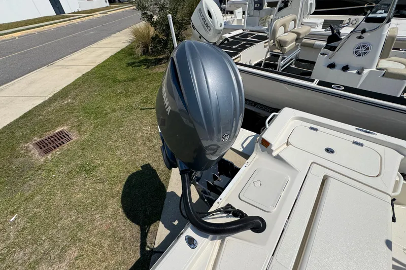 Slide: The Image of 2025 Skeeter SX221 boat with Yamaha outboard motor, parked on grass near a road. - 21