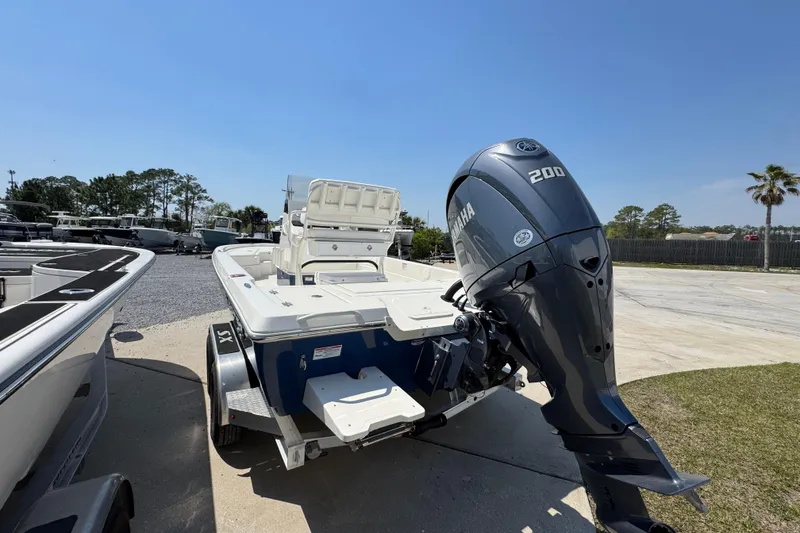 Slide: The Image of 2025 Skeeter SX221 boat with Yamaha 200 engine, parked outdoors under clear blue sky. - 9