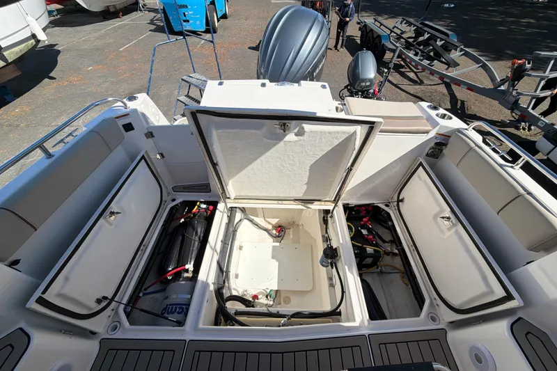 Slide: The Image of 2023 Cutwater C-248 Coupe boat interior with open storage compartments and visible engine components. - 11