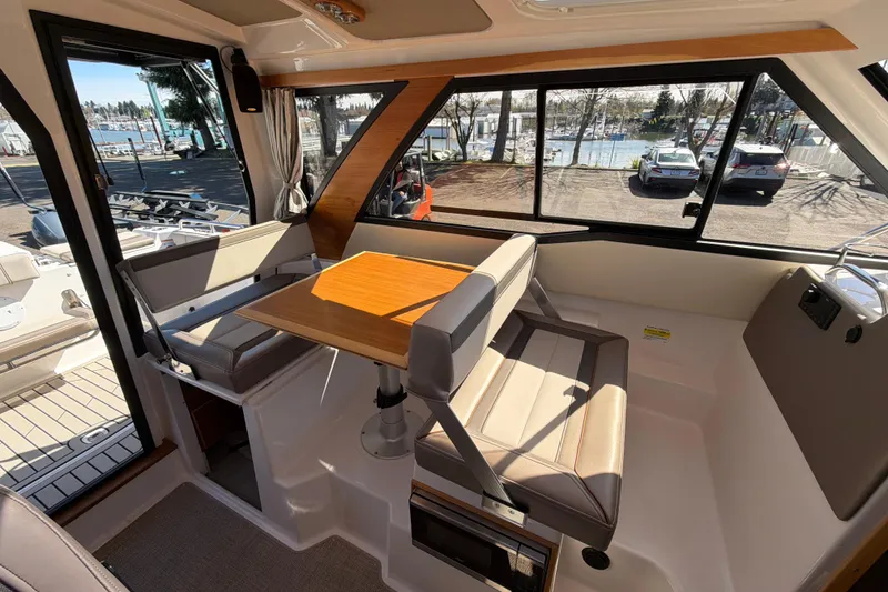 Slide: The Image of Interior of 2023 Cutwater C-248 Coupe with seating and table, marina view. - 16