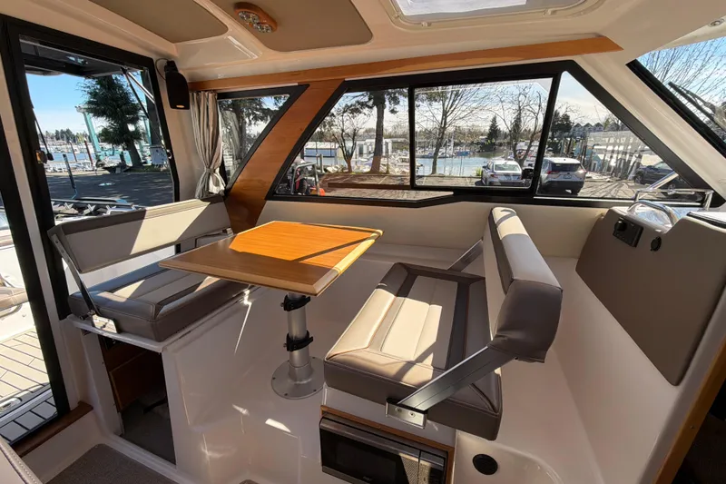 Slide: The Image of Interior of 2023 Cutwater C-248 Coupe with seating and table, marina view. - 17
