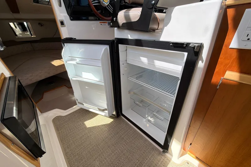 Slide: The Image of 2023 Cutwater C-248 Coupe interior with open refrigerator, showcasing compact and efficient design. - 22