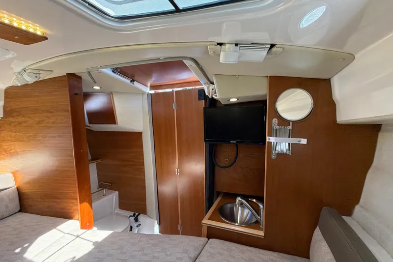 Slide: The Image of Interior of 2023 Cutwater C-248 Coupe featuring a compact kitchenette and cozy seating area. - 25