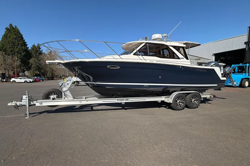 Slide: The Image of 2023 Cutwater C-248 Coupe boat on trailer in parking lot, clear sky background. - 4