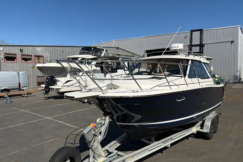 Slide: The Image of 2023 Cutwater C-248 Coupe boat on trailer in industrial setting. - 5