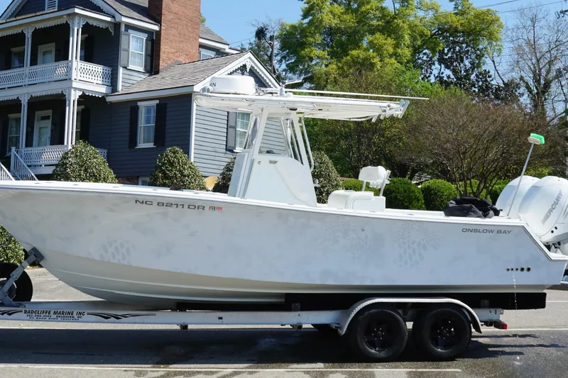 Slide: The Image of 2011 Onslow Bay 27 Offshore boat on trailer, parked near a house. - 11