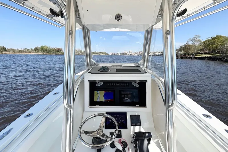 Slide: The Image of 2011 Onslow Bay 27 Offshore boat console with navigation screens on a calm river. - 14