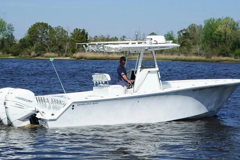 Slide: The Image of 2011 Onslow Bay 27 Offshore boat cruising on a calm lake with trees in the background. - 2
