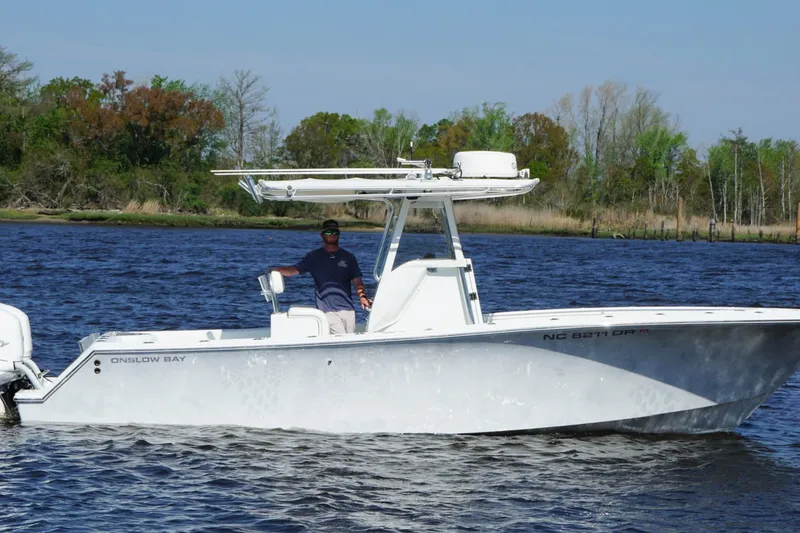 Slide: The Image of 2011 Onslow Bay 27 Offshore boat on water with person, trees in background. - 9