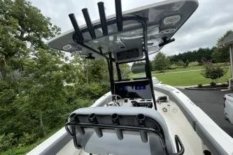Slide: The Image of 2023 NauticStar 24 Legacy boat with T-top and console, parked outdoors. - 8