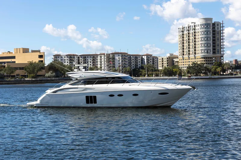 Slide: The Image of 2013 Princess V57 luxury yacht on calm water with cityscape backdrop. - 6