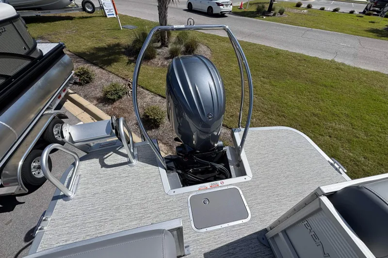 Slide: The Image of 2026 Bennington 22 SSR pontoon boat with outboard motor, parked on grass. - 13