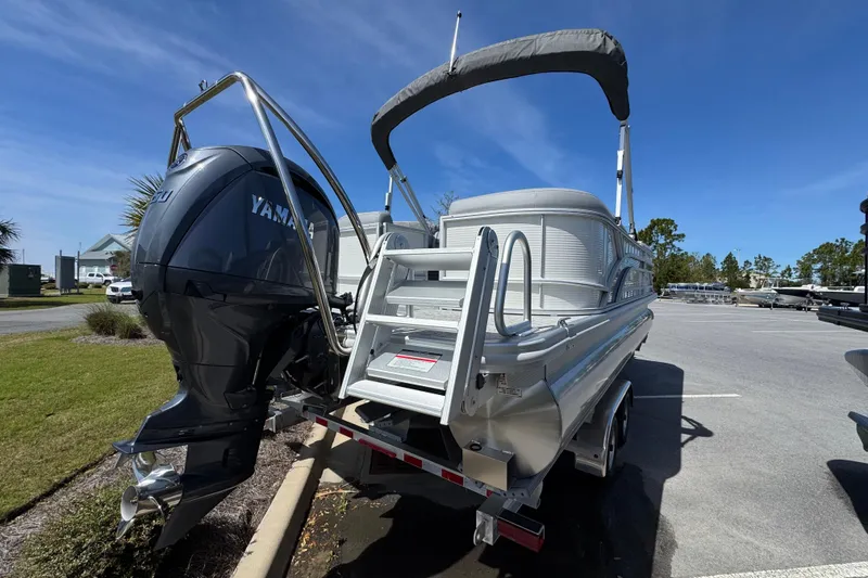 Slide: The Image of 2026 Bennington 22 SSR pontoon boat with Yamaha outboard motor in parking lot. - 2