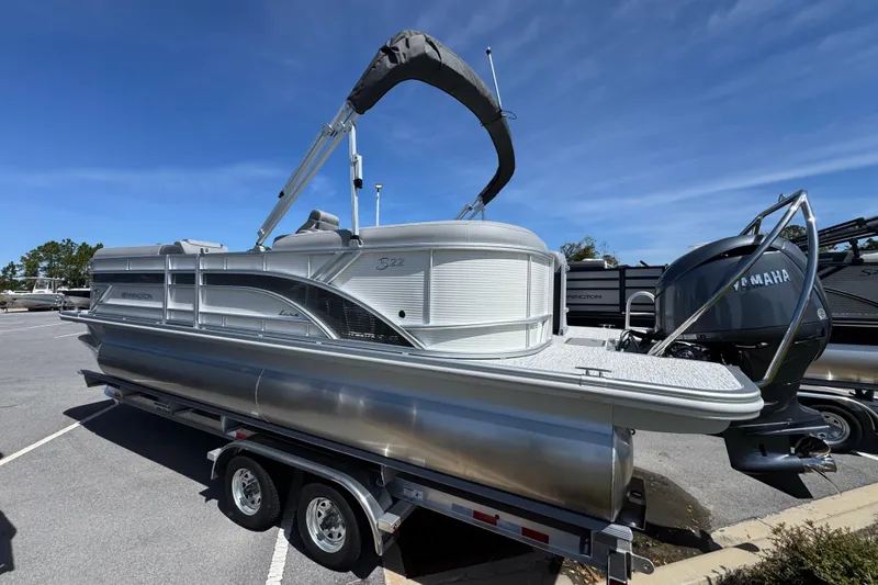 Slide: The Image of 2026 Bennington 22 SSR pontoon boat on trailer, parked outdoors under clear sky. - 4