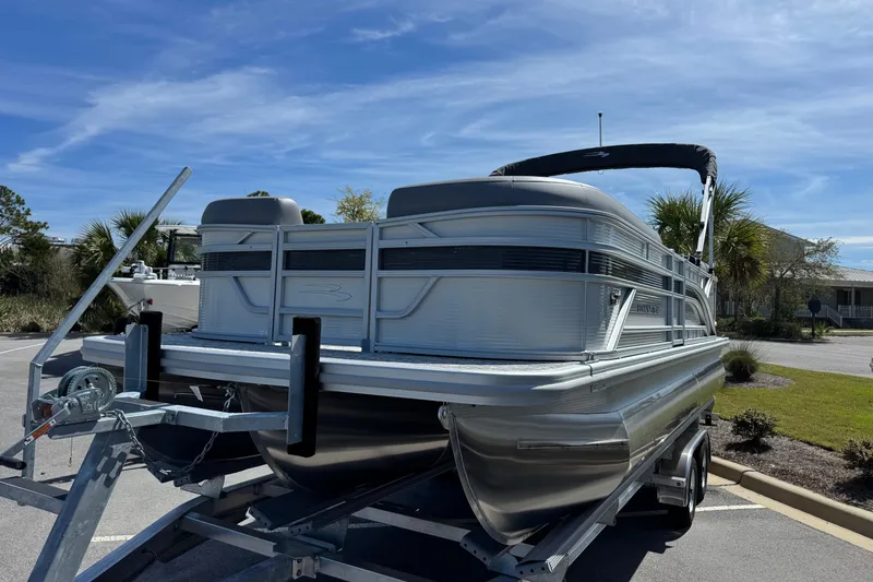 Slide: The Image of 2026 Bennington 22 SSR pontoon boat on trailer under clear blue sky. - 5