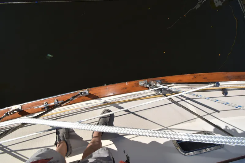 Slide: The Image of Deck view of a 1999 Island Packet 380 sailboat with visible rigging and teak trim. - 17